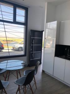 a kitchen with a table and chairs and a window at Apartamentos turísticos Conil luz in Conil de la Frontera