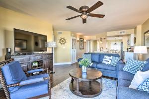 a living room with blue furniture and a ceiling fan at Luxe Oceanfront Condo with Pool Beach Access and Gear in Ormond Beach