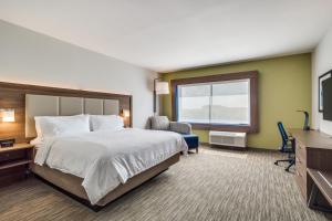 Habitación de hotel con cama y TV en Holiday Inn Express & Suites - Denton South, an IHG Hotel, en Denton