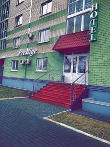 a building with red stairs in front of a building at Hotel Prestige in Barnaul