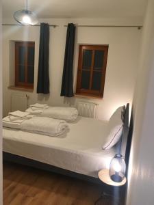 a large white bed in a room with two windows at Nová Pec Holiday Resort Lipno in Nová Pec