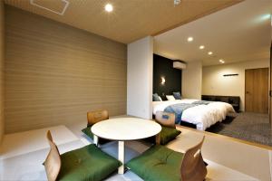 sypialnia z łóżkiem, stołem i krzesłami w obiekcie Apartment Hotel STAY THE Kansai Airport w mieście Izumisano