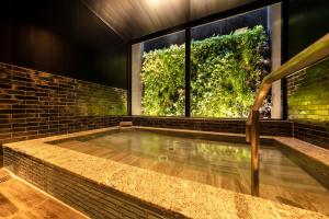 名古屋市にある三交インGrande名古屋 -HOTEL & SPA-のレンガの壁の屋内スイミングプール