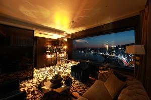 a living room with a large view of a city at Best Louis Hamilton Hotel Gwangan in Busan