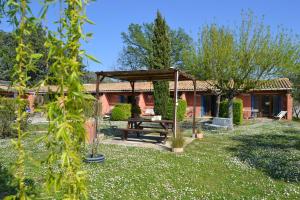 a garden with a picnic table and a pavilion at Village de gîtes Les Olivettes in Saint-Dézéry