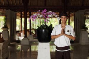 a man standing in front of a vase of flowers at The Ubud Village Resort & Spa in Ubud
