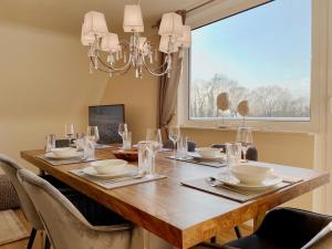 a dining room table with chairs and a large window at Ferien-Apartment Eisvogel im Naturschutzgebiet mit Privatstrand in Friedrichshafen