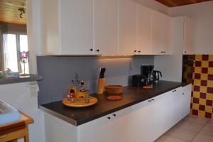 a kitchen with white cabinets and a tray of food on a counter at Village de gîtes Les Olivettes in Saint-Dézéry
