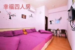 a purple bed in a room with a table at FuLu home stay in Chulu