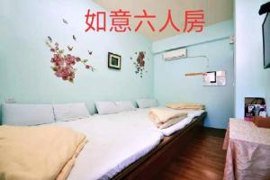 1 dormitorio con 2 camas y escrito en la pared en FuLu home stay, en Chulu
