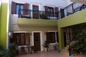 a building with a balcony and a table and chairs at Preveli Apartments in Rethymno