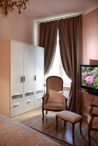 een slaapkamer met een dressoir, een stoel en een televisie bij Zur Eiche Potsdam in Potsdam