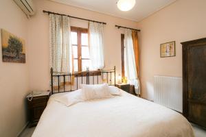 a bedroom with a bed with white sheets and a window at Gastronomy Hotel Kritsa in Portaria