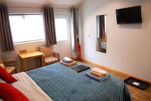 a bedroom with a bed with a blue blanket and a tv at No9 Guesthouse in Hunstanton