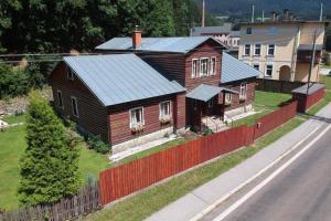 a small house with a red fence next to a road at Chata Paperule in Horní Maršov