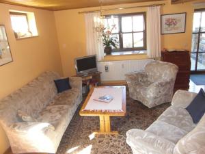 a living room with couches and a coffee table at Ferienwohnung Klüpfelsmühle in Schonungen