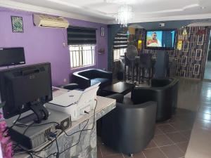 a salon with a desk with a computer and chairs at StayCation Suites And Apartment in Lagos