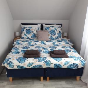 een bed met blauwe en witte lakens en kussens bij Top Alex domki Międzyzdroje in Międzyzdroje