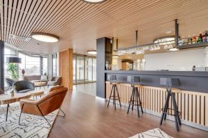 a living room with a bar in a building at All Suites Appart Hôtel Massy Palaiseau in Palaiseau