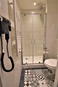La salle de bains est pourvue d'une douche et de toilettes. dans l'établissement Hôtel Bonne Nouvelle, à Paris