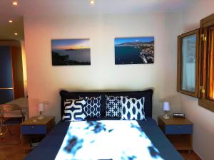 um quarto com uma cama com três fotografias na parede em Chalet Paradiso em Sorrento