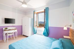 a bedroom with a bed and a desk and a window at Poggiolivi Agriturismo Bio in Maremma in Alberese