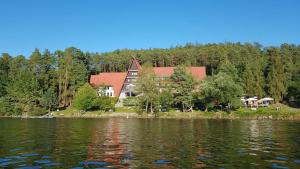 ein großes Haus am Ufer eines Sees in der Unterkunft Hotel Laguna Slapy in Netvořice