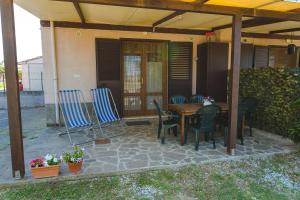 een patio met een tafel en stoelen onder een dak bij Agriturismo Ferri in Bibbona