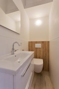 een witte badkamer met een wastafel en een toilet bij Bed en Brood Donna in Pijnacker