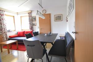 ein Wohnzimmer mit einem Tisch, Stühlen und einem Sofa in der Unterkunft Haus Fiegl in Sautens
