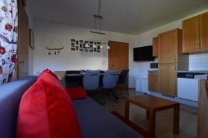 ein Wohnzimmer mit einem blauen Sofa und einer Küche in der Unterkunft Haus Fiegl in Sautens