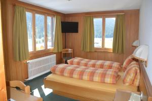 uma sala de estar com um sofá e janelas em Hotel Seeblick em Sufers