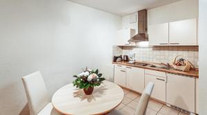 a kitchen with a table with a vase of flowers on it at Aparthotel Münzgasse An der Frauenkirche in Dresden