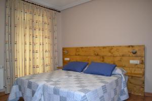 a bedroom with a bed and a dresser at Hostal Aribel Longinos in Cercedilla