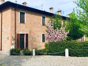 a brick house with a flowering tree in front of it at Agriturismo Da Luca in Calendasco