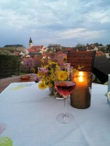 ein Glas Wein auf einem Tisch mit Blumen in der Unterkunft Karolingerweg in Lauterhofen
