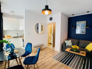 a living room with a couch and a table and chairs at Apartament Niedźwiadek in Ustrzyki Dolne