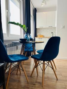 a dining room with blue chairs and a table at Apartament Niedźwiadek in Ustrzyki Dolne