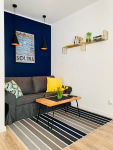 a living room with a couch and a table at Apartament Niedźwiadek in Ustrzyki Dolne