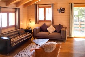 a living room with two couches and a table at 3-Schlafzimmer Chalet Eichhorn****, Saas Fee 1800m in Saas-Fee