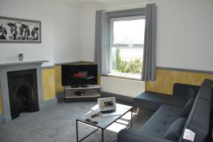 a living room with a couch and a tv at Maytree 2 Bed Apartment - STAYSEEKERS in Salisbury