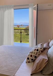 a bedroom with a bed with a view of the ocean at Megali Beach Nikos in Sidari
