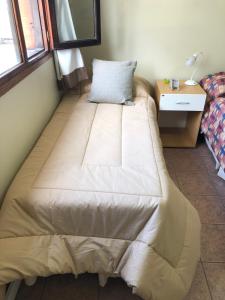 een groot bed in een kamer met een nachtkastje en een bed sidx sidx sidx bij A un paso de todo !!! Lo de Richard in Ushuaia