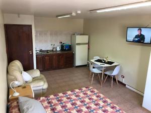 een woonkamer met een bank en een tafel en een keuken bij A un paso de todo !!! Lo de Richard in Ushuaia