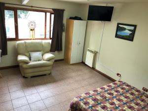 1 dormitorio con silla, cama y ventana en En Pleno centro!! Lo de Miriam en Ushuaia