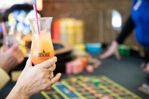 a person holding up a glass with a drink at Mineral Palace Hotel & Gaming in Deadwood