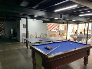 a pool table in a room with two tables at Mumma's Hostel Cairns in Cairns