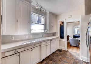 a kitchen with white cabinets and a sink and a window at 30 Day+ Craftsman; Stroll 2 Food & Downtown! in Portland +37 photos