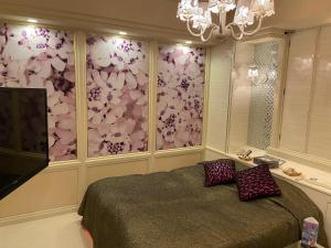 所沢市にあるレステイ 所沢（大人専用）のベッドルーム1室(ベッド1台付)、花の壁
