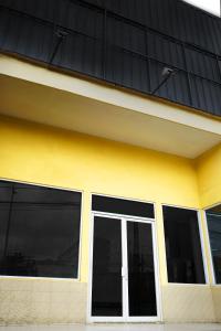 ein gelbes und schwarzes Gebäude mit einem Fenster in der Unterkunft UROOMS Tanah Abang in Jakarta
